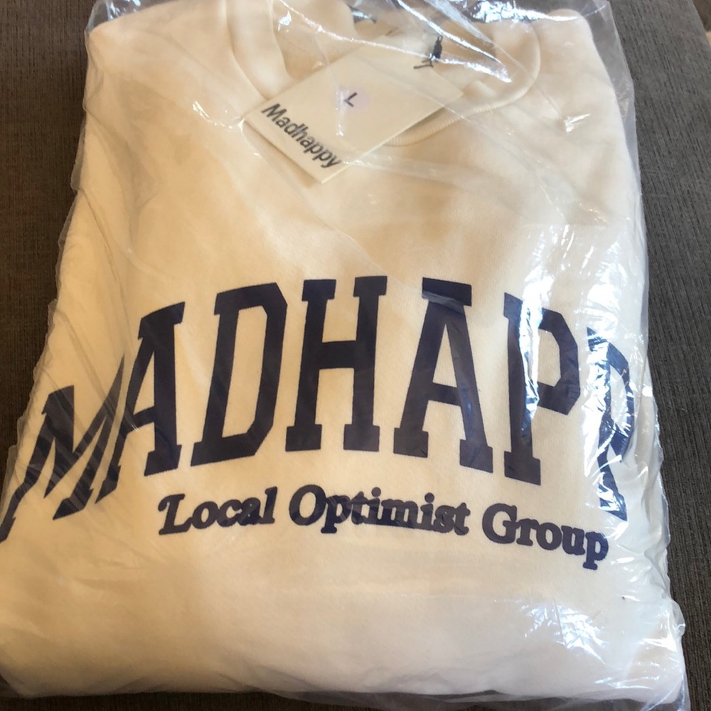 Blue letters. Off white sweater.